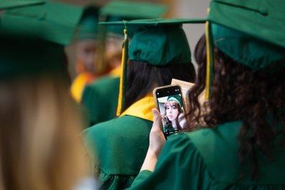 A student takes a selfie before commencement